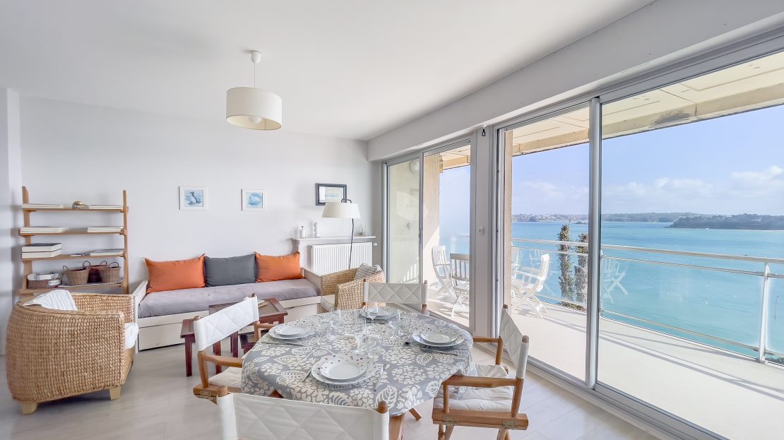 Salle à manger et salon modernes avec vue sur la mer à travers des baies vitrées