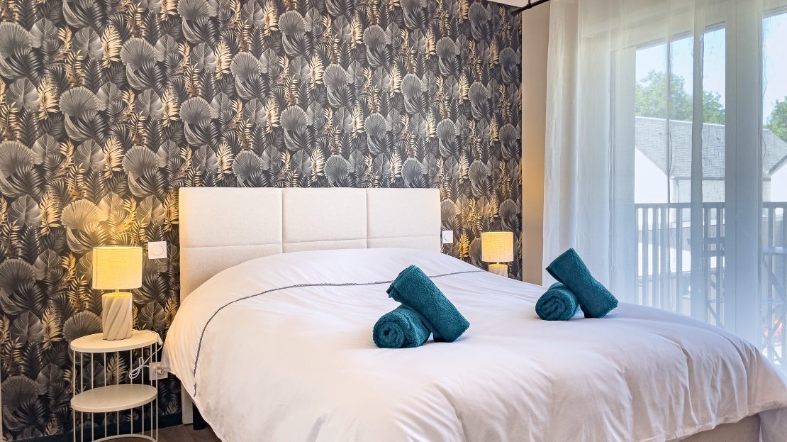 Chambre à coucher avec lit et papier peint tropical
