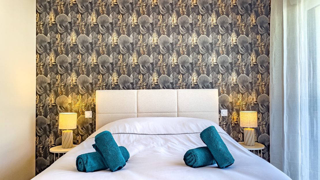 Chambre à coucher de luxe avec lit et papier peint tropical