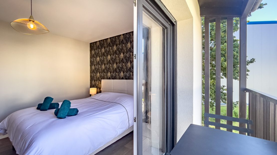 Chambre d'hôtel avec balcon et vue sur l'extérieur