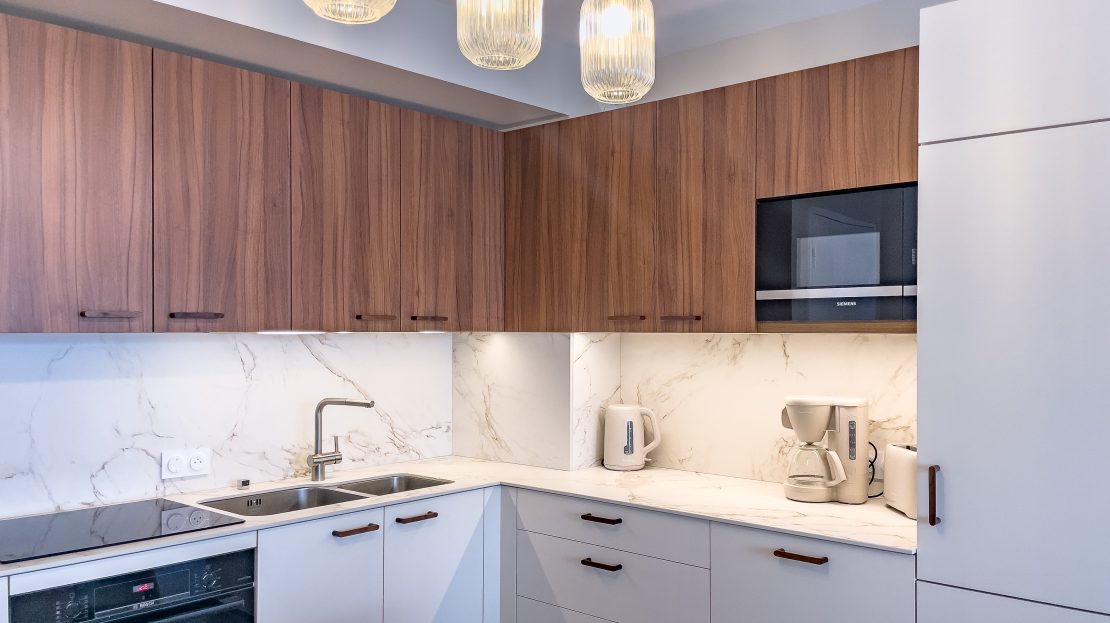 Cuisine moderne avec meubles en bois et plans de travail en marbre