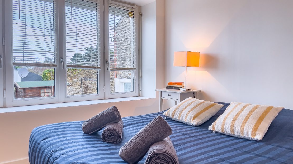 Chambre avec lit double et serviettes roulées