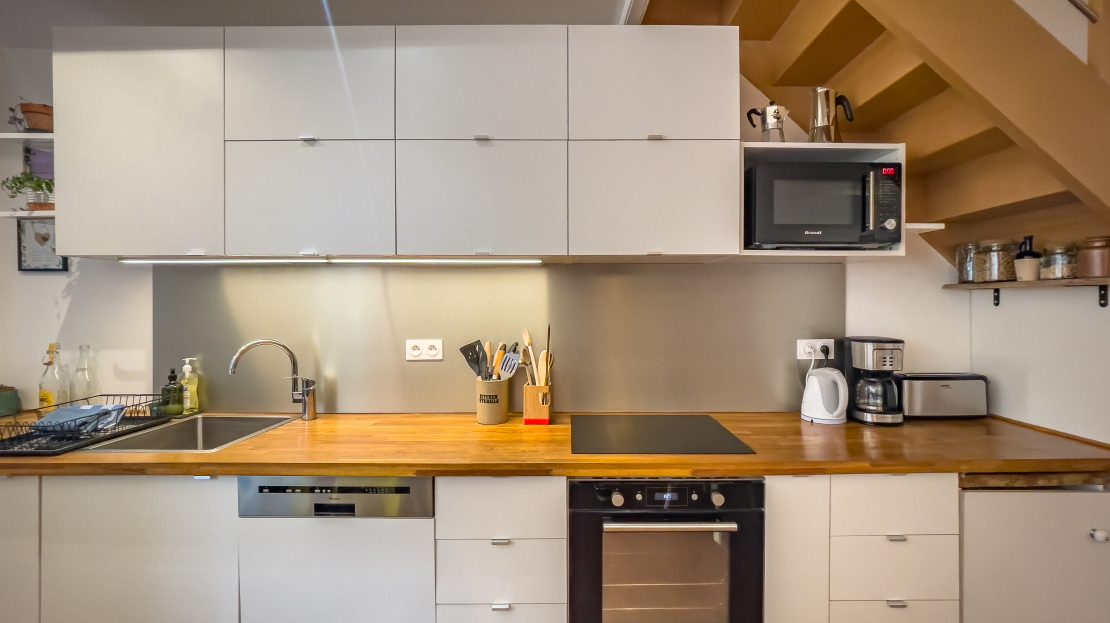 Cuisine blanche avec plan de travail en bois et équipements modernes