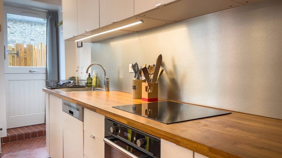 Cuisine moderne avec meubles blancs et plan de travail en bois