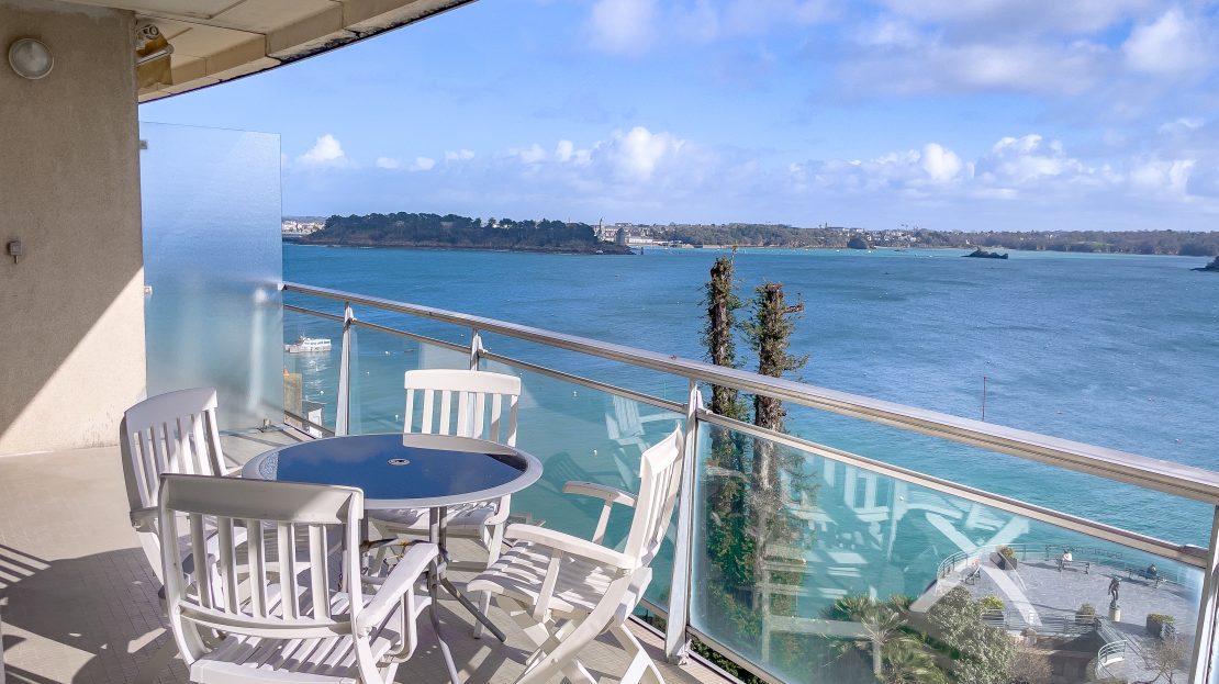 Terrasse avec vue sur la mer et mobilier de jardin blanc
